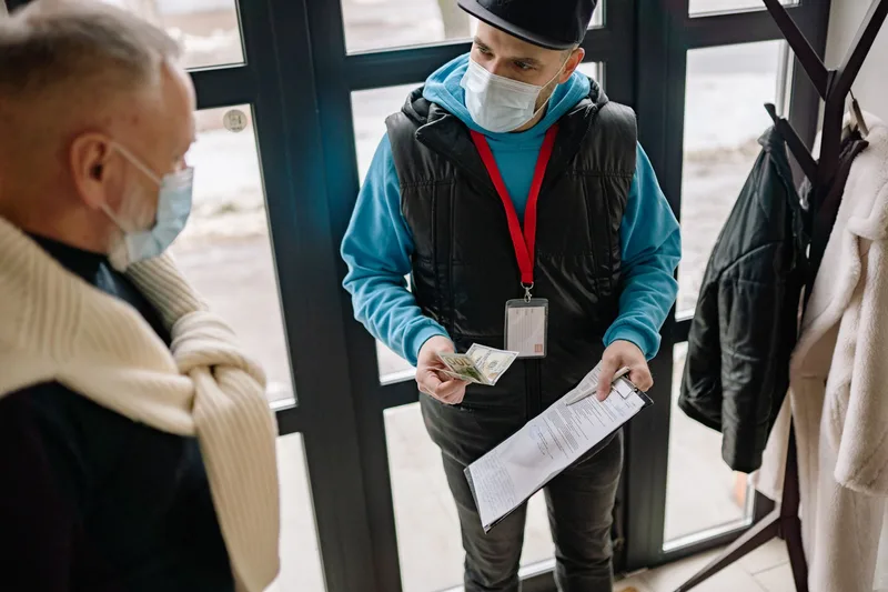 Delivery courier receiving a cash payment for a package from a customer