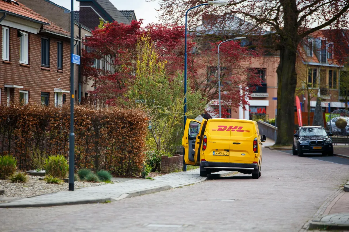 DHL delivery van on a Malaysian street next to competitive courier vehicles illustrating the Malaysian courier market