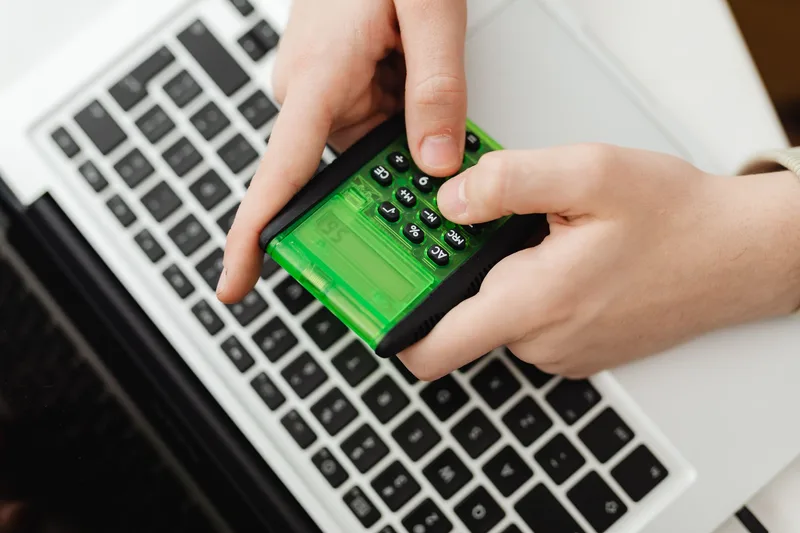 Ecommerce seller calculating shipping cost per order using a calculator